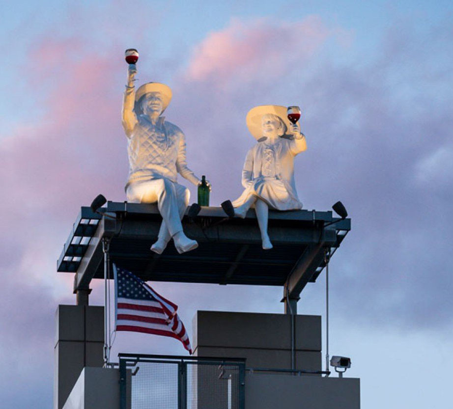 A picture of two sculptures of people on top of a building. Robert and Margrit Mondavi